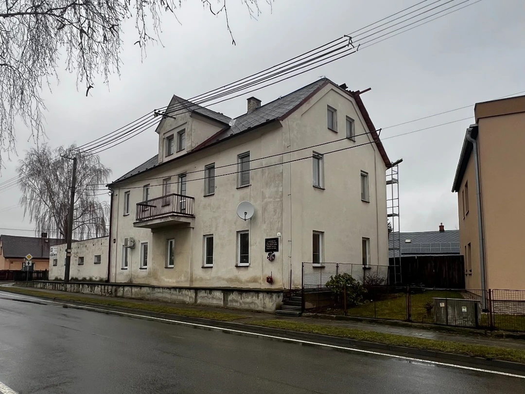 Bytový dům v Hlavnici před renovací, s původní omítkou a okny.